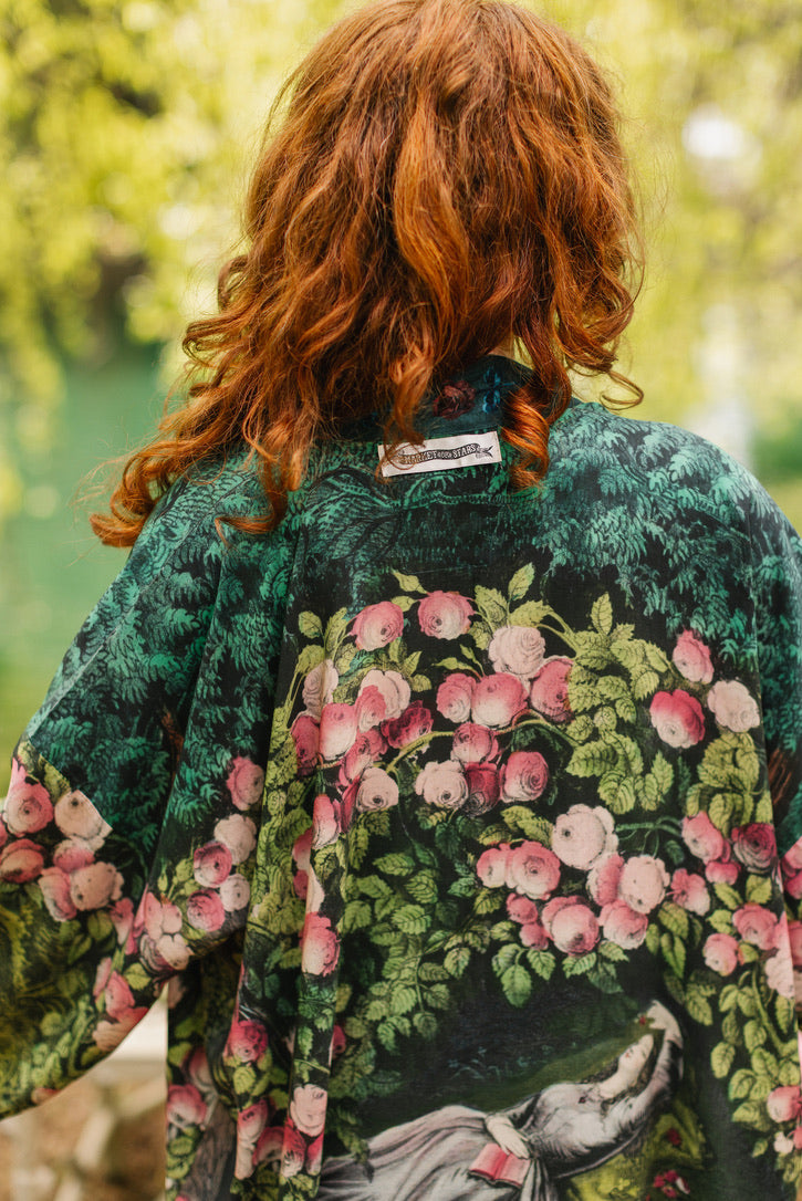 Person wearing a floral kimono with a blurred natural background